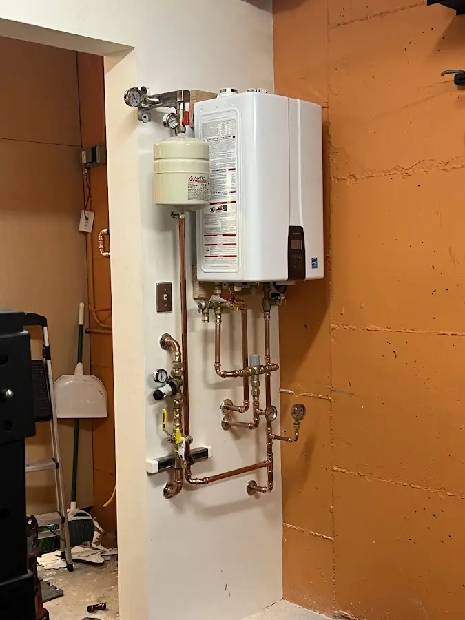 Plumbing technician inspecting water heater connections in Desloge